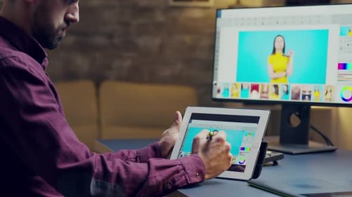 Man Doing Photo Retouching on Tablet at Desk