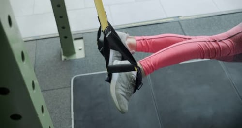 Beautiful Young Woman Does Training with Fitness Straps in Gym. Attractive Female Training