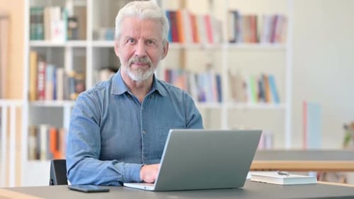 Senior Man Working on Laptop Gives Thumbs Up
