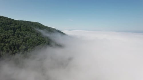 Flying Through the Clouds Above Mountain Tops