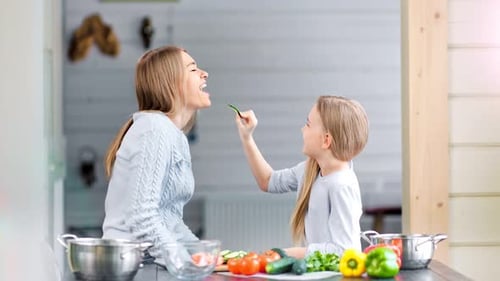 Mother and Daughter are Fooling Around and Playing in a Kitchen
