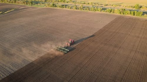 Aerial View Modern Red Tractor on the Agricultural Field on Sunset Time, Tractor Plowing Land