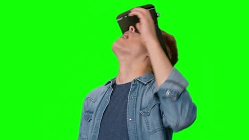 Man Experiments with Virtual Reality Headset on Green Screen