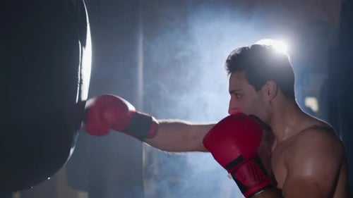 Powerful Male Boxer Training in Gym