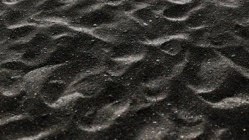 Seamless Black Sand Texture Loop with Dynamic Light Movement