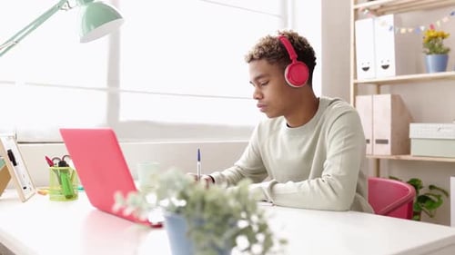 Young Student Man Studying Online on Laptop Computer in His Studio Room