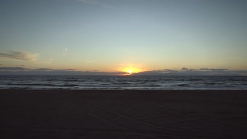 Aerial view of a empty sandy beach at sunset in Greece.