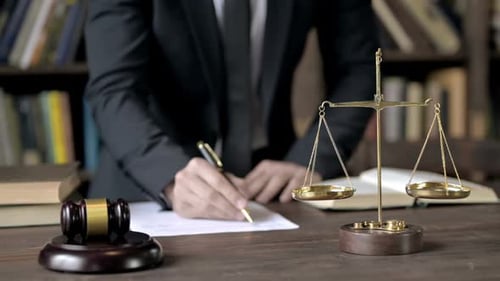 Close Shoot of Judge Hand Writing Document in Court Room