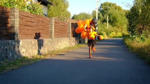 Girl in Halloween Costume Runs with Balloons