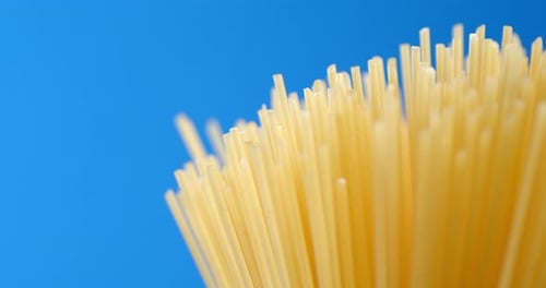 Close up of Uncooked Spaghetti on Blue