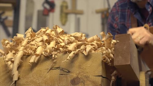 Cabinet Maker Planes Solid Wood in his Workshop