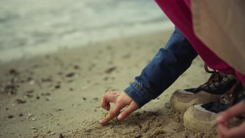 Little Kid Drawing Sand at Ocean Beach