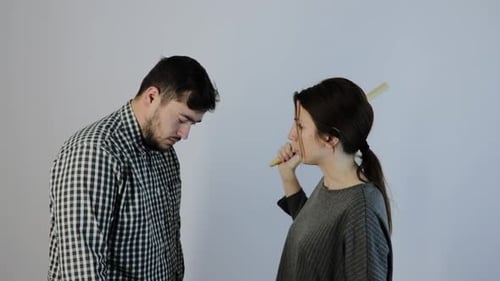 Woman Yelling at Man with Stick Indoors