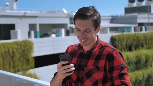 Young Adult Using Mobile Phone Outdoors in City