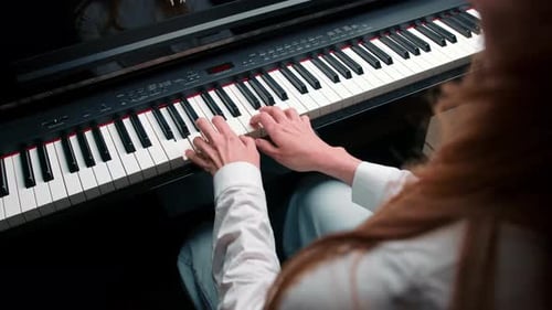 Close-up: a woman sensually plays the piano