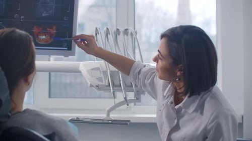 Dentist Explains X-Ray Results to Patient in Office