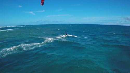 Aerial view of a man kitesurfing in Hawaii.