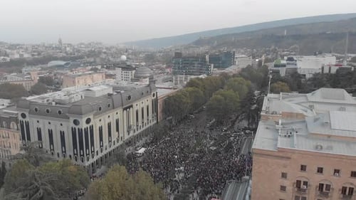 Crowd of People Gather in a City Aerial