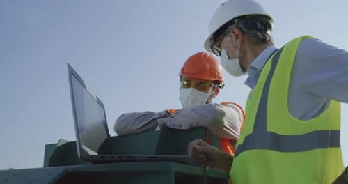 Engineers Reviewing Laptop on Construction Site, Daytime