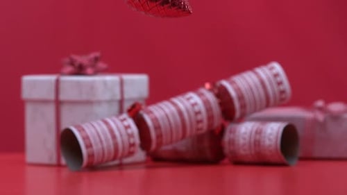 Christmas decoration dropping and bouncing beside crackers and presents