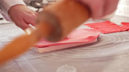 Confectioner Rolls Out Dough Mastic for Decorating Cake Pastries