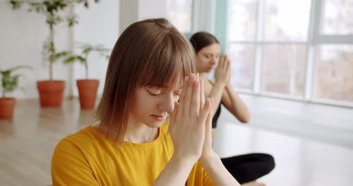 Women Meditating Indoors in Bright Yoga Studio