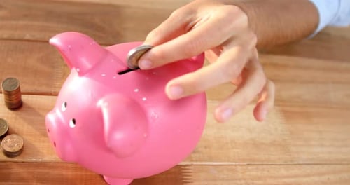 Woman putting coin in piggy bank