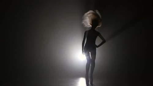 Blonde sexy Mädchen tanzt auf High Heels. Dark Smoke Studio