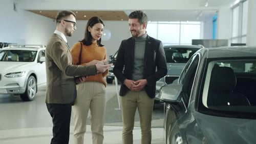 Car Salesman Talking with a Couple in Dealership