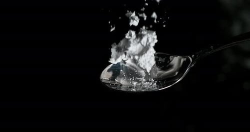 Drug, Cocaine in spoon against black background, Slow motion 4K