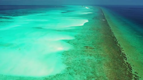 Beautiful scenery of tropical paradise with shiny turquoise lagoon, brown coral reefs and deep blue