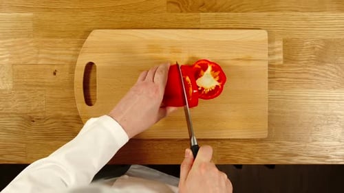 Cook Slicing Red Bell Pepper on Cutting Board