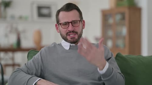 Man Speaking and Gesturing on a Couch