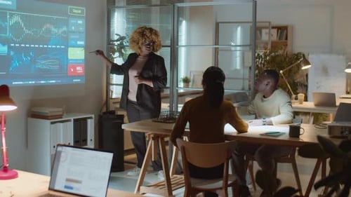 African American Woman Giving Presentation at Night Business Meeting