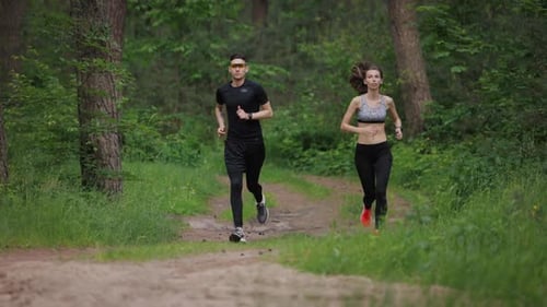 Young Couple Jogging Together on Forest Path