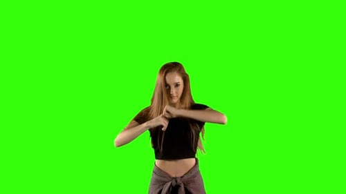 Young woman dancing against green screen background