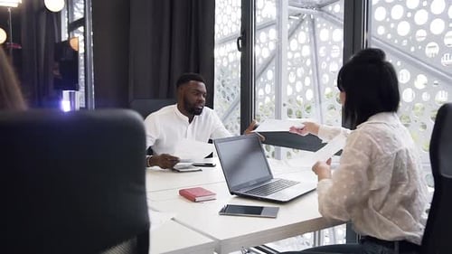 Attractive Mixed Races Female and Male Business People Working with Documents in the Office