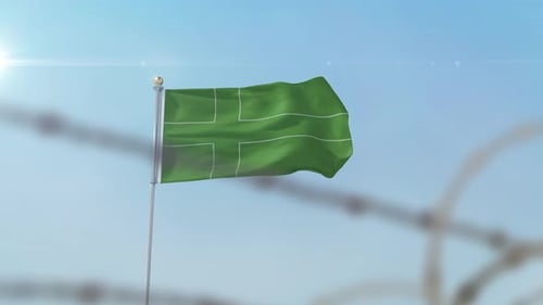 Waving Green Flag with Grid Pattern Behind Barbed Wire