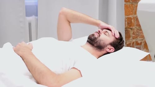 Unbequemer Bartmann schläft nachts im Bett Unruhe