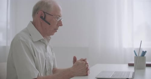 Senior Man Video Calling at Home on Laptop