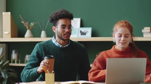 Young Adults Working Together at Desk in Office