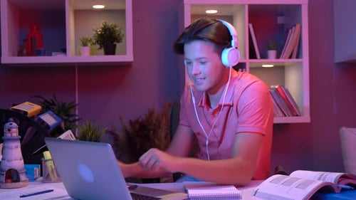 Teen Using Laptop at Desk With Headphones