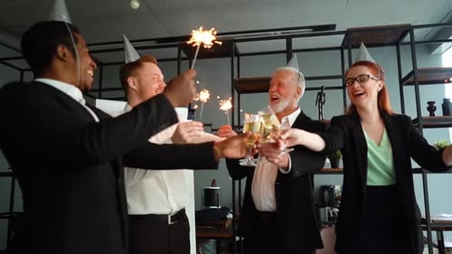 Equipe de negócios de colegas de trabalho multiétnicos, pessoas segurando luzes de Bengala, tilintando taças de champanhe.