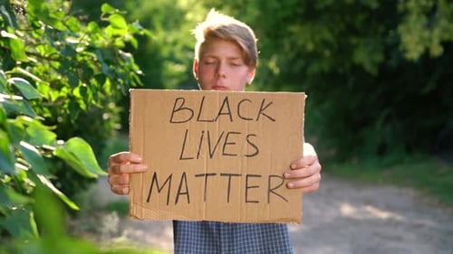 Young Person Holding Sign in Natural Setting