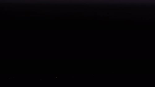 Lightning Bolts in the Stormy Clouds at Night Sky Above The City Buildings