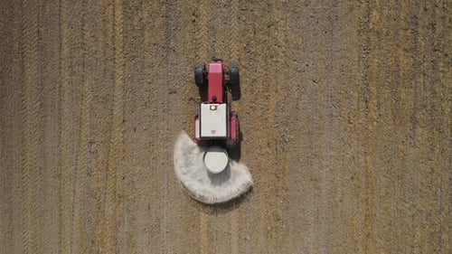 Aerial View of Tractor Spreading Fertilizer on Field