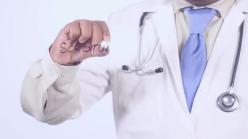 Male Doctor Writing 'Scrotum' on Transparent Surface