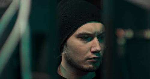 Portrait d'un pirate informatique portant un sweat-shirt et une casquette tente de pirater un système de sécurité pour