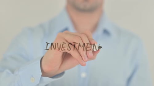 Man Writing Investment on Clear Surface
