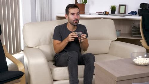 Young Man Plays Video Game on Couch